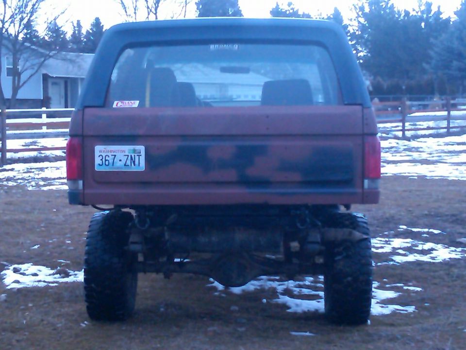 Rear view of a lifted Ford Bronco with camouflage paint on the tailgate. Washington license plate 367-ZNT is visible