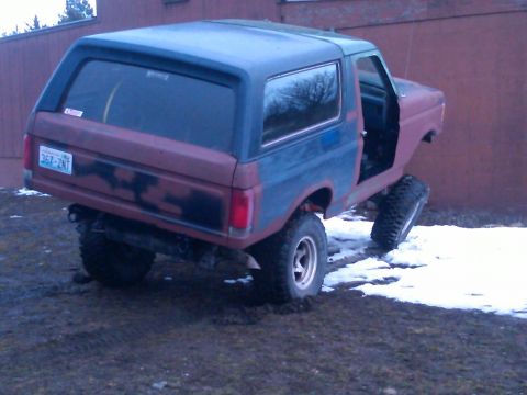 1988 Ford Bronco - This 1988 Ford Bronco, seen from a 3q-front angle, features a red and blue paint scheme and off-road tires.