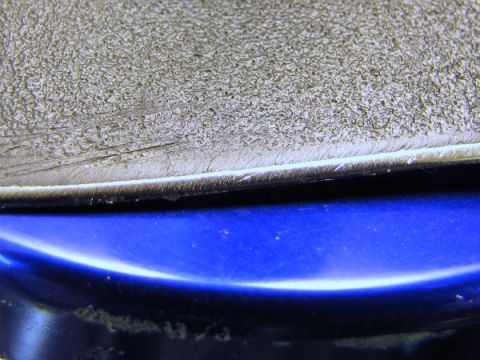 1984 Ford Bronco - A detailed view shows a textured surface meeting a smooth blue painted section, separated by a thin white edge.