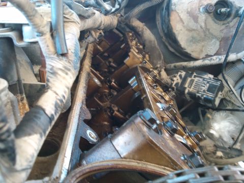 1998 Ford Crown Victoria - Close-up view of an engine with the valve cover removed, revealing internal mechanical parts.