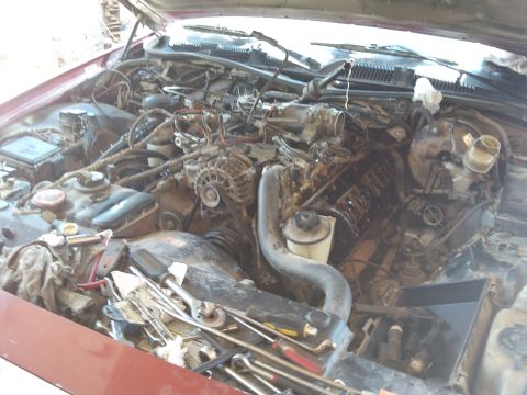 1998 Ford Crown Victoria - Engine bay with tools scattered around, suggesting maintenance or repair work is in progress.