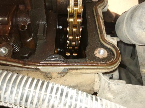1998 Ford Crown Victoria - Close-up view of an engine's timing chain and valve cover gasket, showing internal mechanical components.