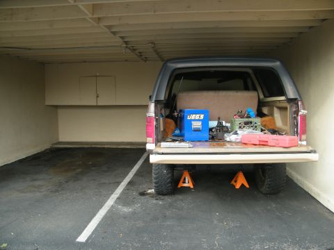 1982 Ford Bronco - The rear of a 1982 Ford Bronco is shown with its tailgate open, revealing various items stored within the cargo area.