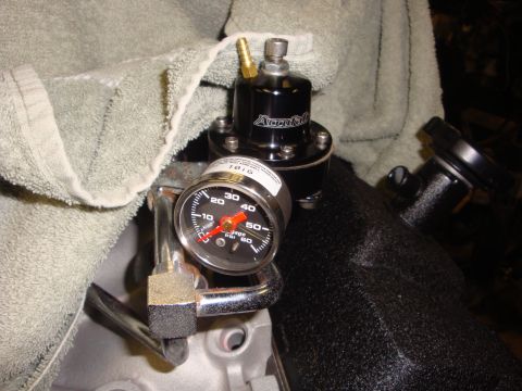 1989 Ford Bronco - A close-up view of a fuel pressure regulator and gauge installed on an engine.