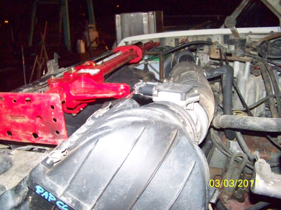 Air cleaner box and mass air flow sensor in engine bay with red jack on fender