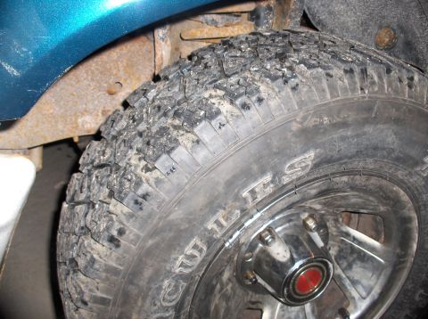 1994 Ford F-150 - A close-up view of a tire and wheel well, showing dirt and rust. The registry claims it is a 1994 Ford F-150, but this is not verifiable fr…