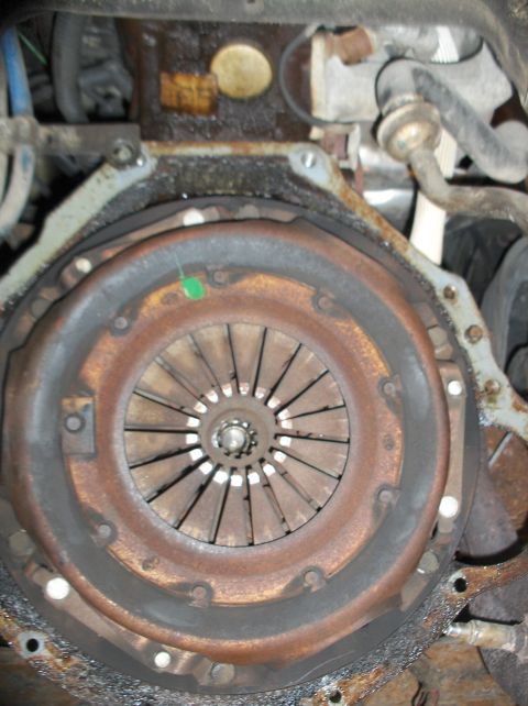 1994 Ford F-150 - Close-up view of a vehicle's clutch and flywheel assembly, showing signs of wear and rust.