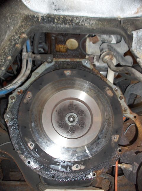 1994 Ford F-150 - Close-up view of an engine's flywheel, showing its bolted assembly and surrounding mechanical parts.