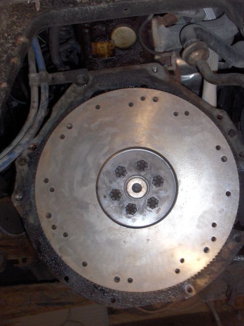 1994 Ford F-150 - Close-up view of a vehicle's flywheel and surrounding engine parts, showing mechanical parts and fluid lines.