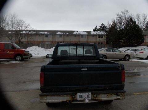 1994 Ford F-150 - Rear view of a 1994 Ford F-150 pickup truck in a parking lot on a cloudy day.