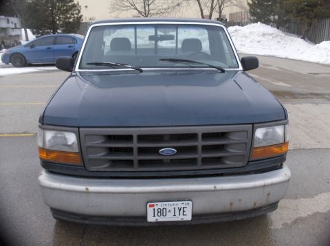 1994 Ford F-150 - This dark blue Ford F-150 pickup truck is shown from the front, displaying its grille and bumper.