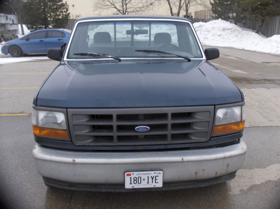 Dark blue 1992 Ford F-150 front view with a gray grille and chrome bumper