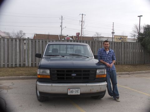 1994 Ford F-150 - A man poses with his Ford F-150 pickup truck parked in a lot.