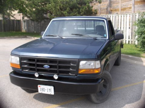 1994 Ford F-150 - This 1994 Ford F-150 pickup truck is shown from the front 3/4 angle, its distinctive grille and headlights.