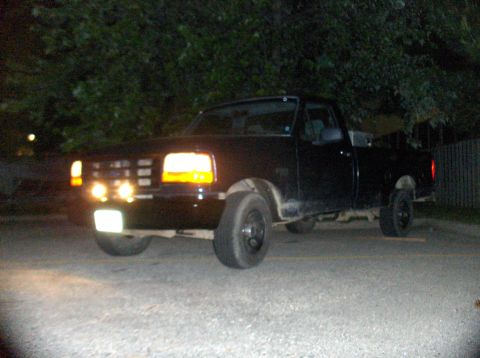 1994 Ford F-150 - This 1994 Ford F-150 pickup truck is seen parked outdoors at night with its lights illuminated.