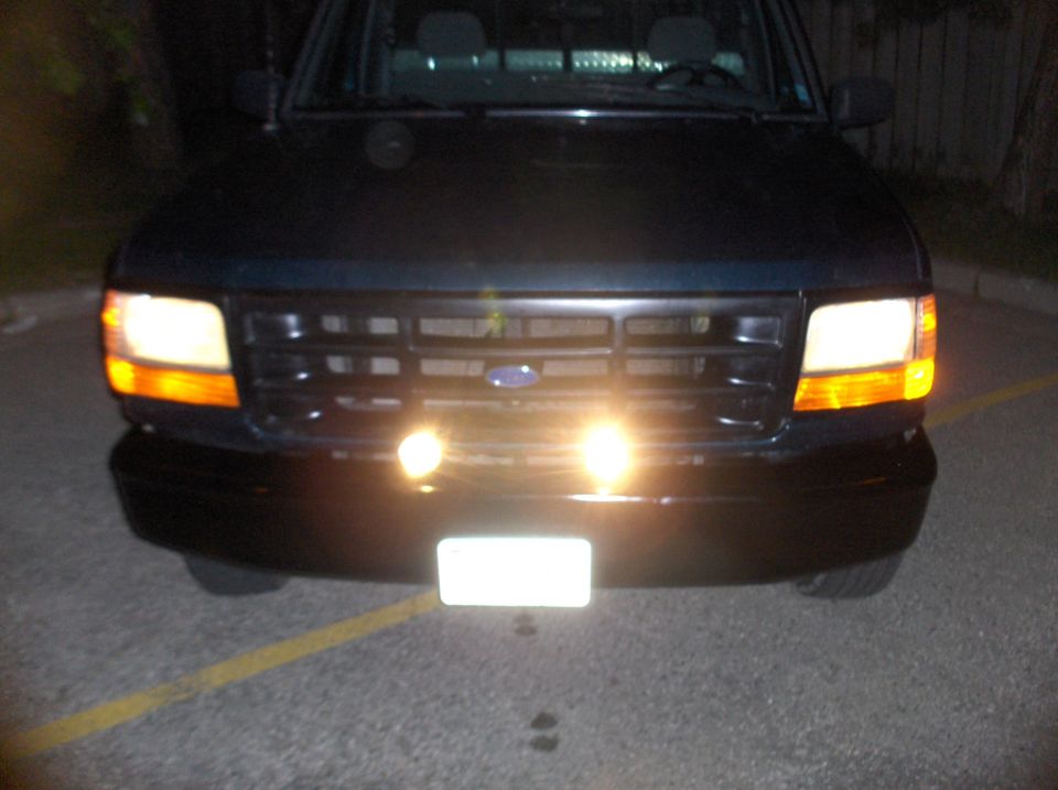 Front view of a dark-colored Ford truck with a grille and headlights. The grille design suggests a 1992-1996 model year