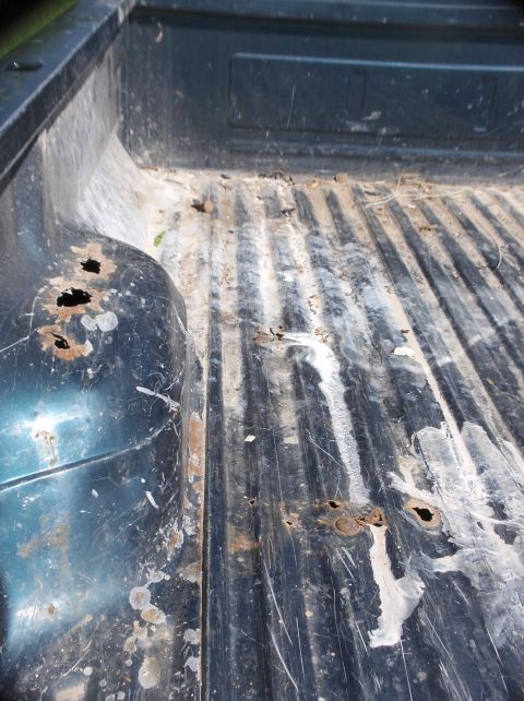 1994 Ford F-150 - The bed of a 1994 Ford F-150 shows significant rust damage and wear.