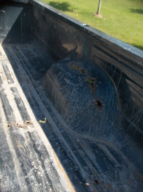 1994 Ford F-150 - The interior of a truck bed shows wear and tear with visible rust.
