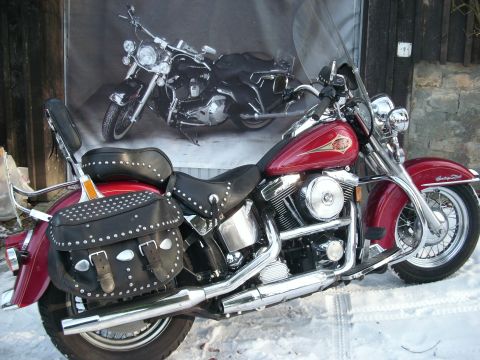 1999 Lincoln Town Car - A red Harley-Davidson motorcycle with studded saddlebags sits in the snow, with a banner of another motorcycle in the background.
