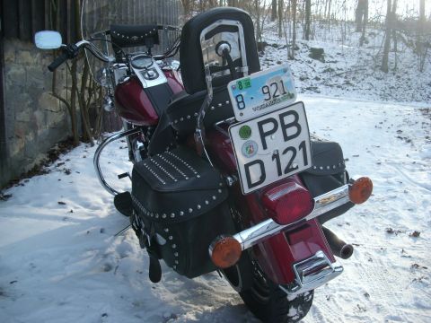 1999 Lincoln Town Car - A motorcycle with studded saddlebags sits in the snow, displaying two license plates.