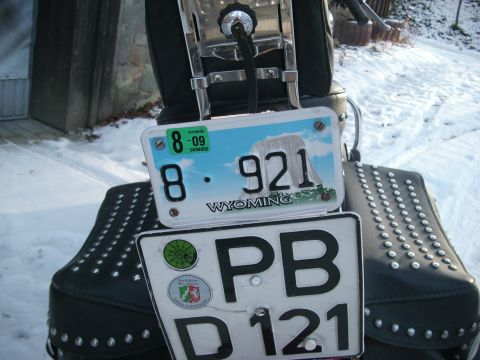 1999 Lincoln Town Car - Two license plates are attached to the back of a motorcycle, one from Wyoming and another from Germany, with snow on the ground.