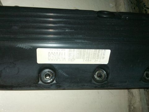 1998 Ford Crown Victoria - Close-up of a black engine part with a white label indicating a date of 4/15/98 and a barcode.