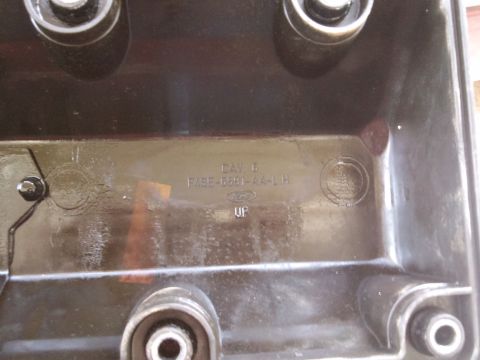1998 Ford Crown Victoria - Close-up of a black valve cover with embossed part numbers and manufacturer logo.