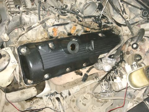 1998 Ford Crown Victoria - Close-up view of an engine bay with the valve cover removed, revealing internal mechanical parts during a repair.