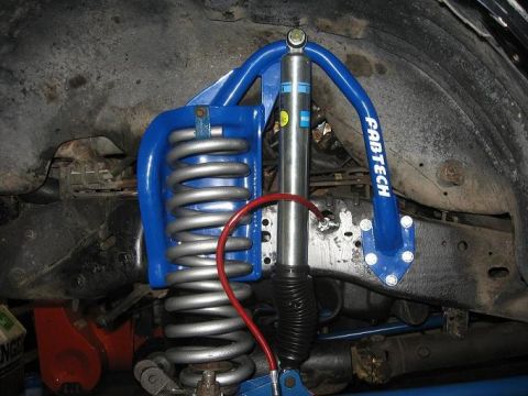 1993 Ford Bronco - Close-up of Fabtech suspension lift components, including a coilover and brake line.
