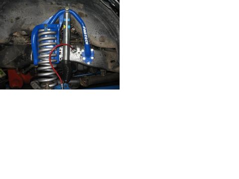1993 Ford Bronco - A close-up view of a vehicle's suspension system, highlighting a blue shock absorber and coil spring.