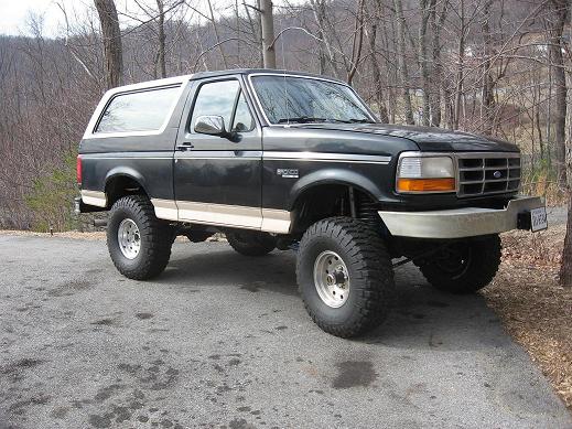 Black lifted 1993 Ford Bronco with tan trim parked on asphalt
