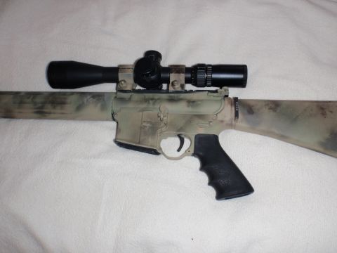 1991 Ford Bronco - A rifle with a scope, painted in a camouflage pattern, is shown against a white background.