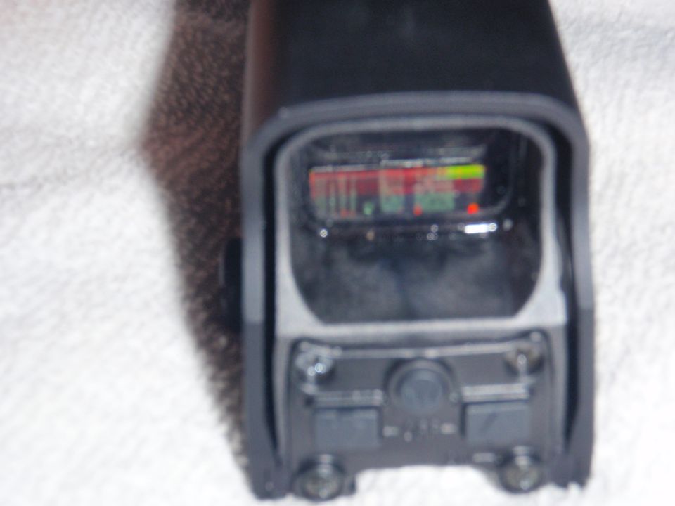 close up of a black red dot sight with a reticle display