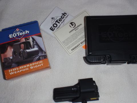 1991 Ford Bronco - The photo displays an EOTech holographic weapon sight, its packaging, and related documentation.