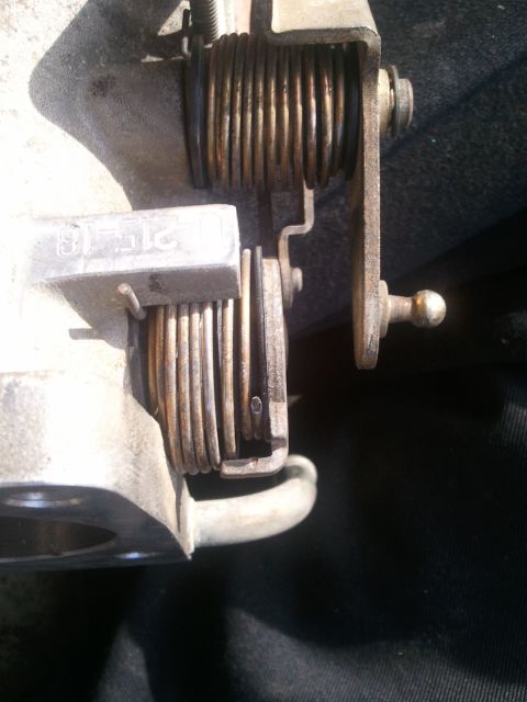 1989 Ford Bronco - Close-up of a throttle body assembly with springs and linkage visible.