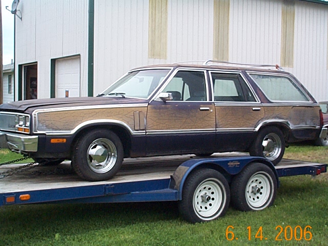 Station wagon with wood paneling on a trailer. It looks like a 1982 Mercury Zephyr
