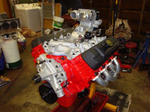 1989 Ford Bronco - Engine assembly with red block, silver intake manifold, and black valve covers, possibly being prepped for installation.