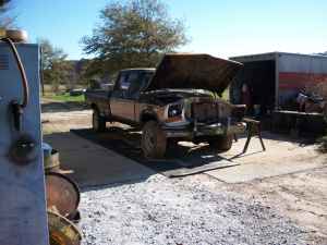 1995 Ford Bronco - This older pickup truck is parked outside with its hood raised, appearing to be undergoing some maintenance.