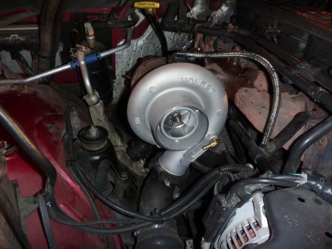 1997 Dodge 2500 - Close-up view of a turbocharger installed in a vehicle's engine bay.