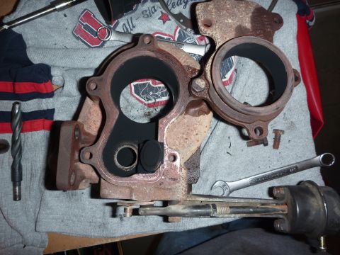1997 Dodge 2500 - A disassembled turbocharger part shows internal soot buildup and is surrounded by tools on a cloth surface.