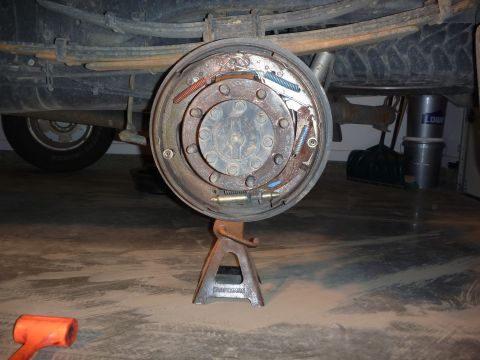 1997 Dodge 2500 - The rear drum brake assembly is shown disassembled and supported by a jack stand.