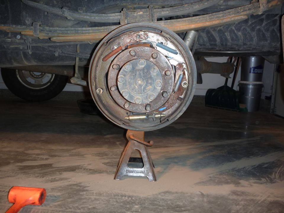 rear drum brake assembly on jack stand, leaf springs above