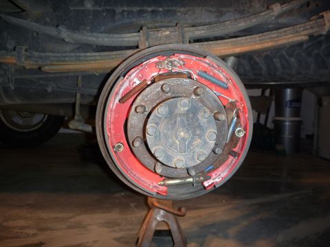 1997 Dodge 2500 - Close-up of a vehicle's rear drum brake assembly, supported by a jack stand.