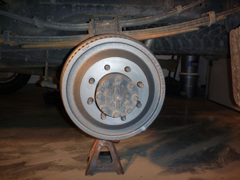 Rear drum brake assembly on jack stands, showing leaf springs above