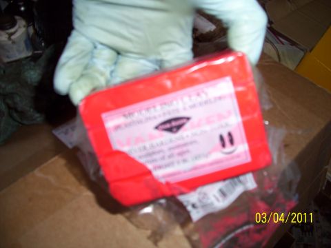 1995 Ford Probe - A red block of modeling clay is held by a gloved hand, with a cardboard box in the background.
