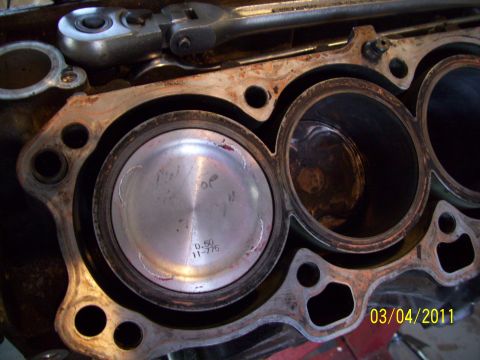1995 Ford Probe - Close-up of an engine block showing pistons and cylinder bores, with a tool resting on top.