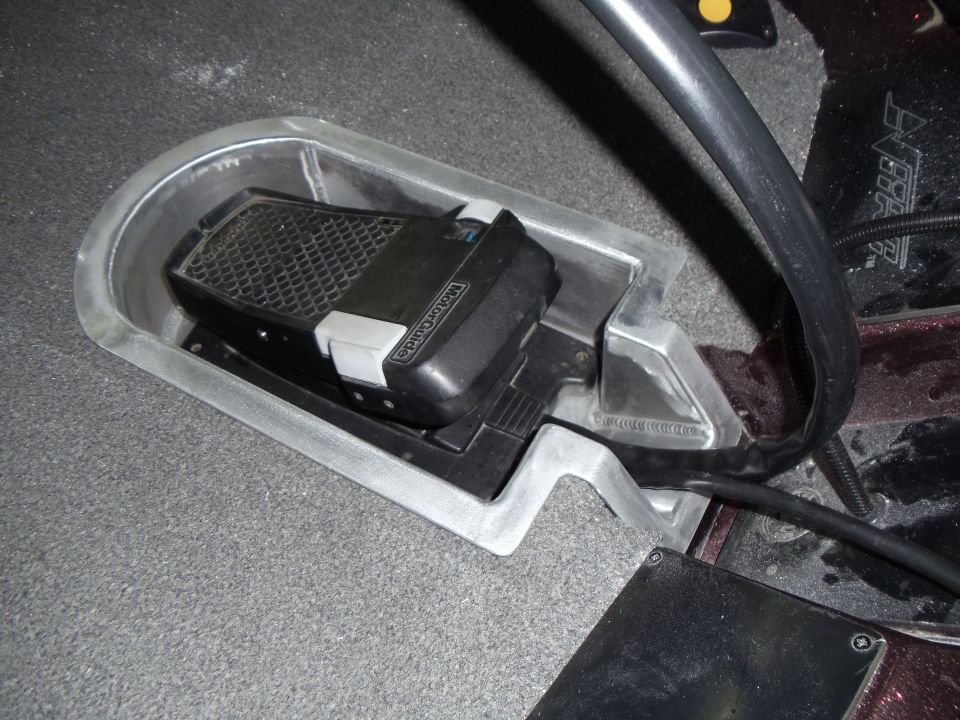 Boat foot pedal in recessed tray. Text on pedal reads MotorGuide