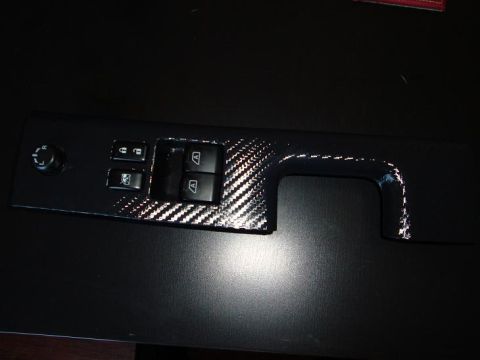 1990 Ford Probe - Close-up of a car's interior door panel window control switches and carbon fiber accents.