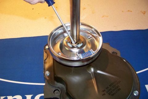 1994 Ford F-150 - A screwdriver is used to adjust a component on a transmission part, with a blue spring visible.