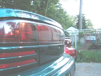 1997 Ford Taurus - The rear of a green Dodge Intrepid is visible, with another vehicle parked behind it.